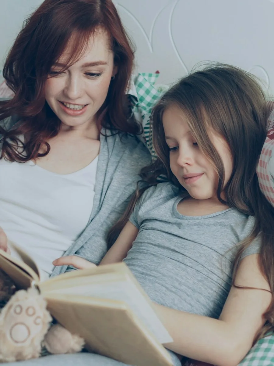 A mother and daughter reading a book together